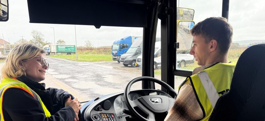 boy sitting behind wheel of a bus